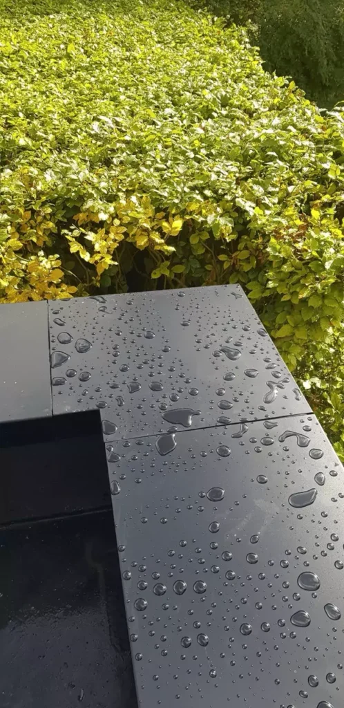 Close-up of aluminium coping with raindrops, Henley