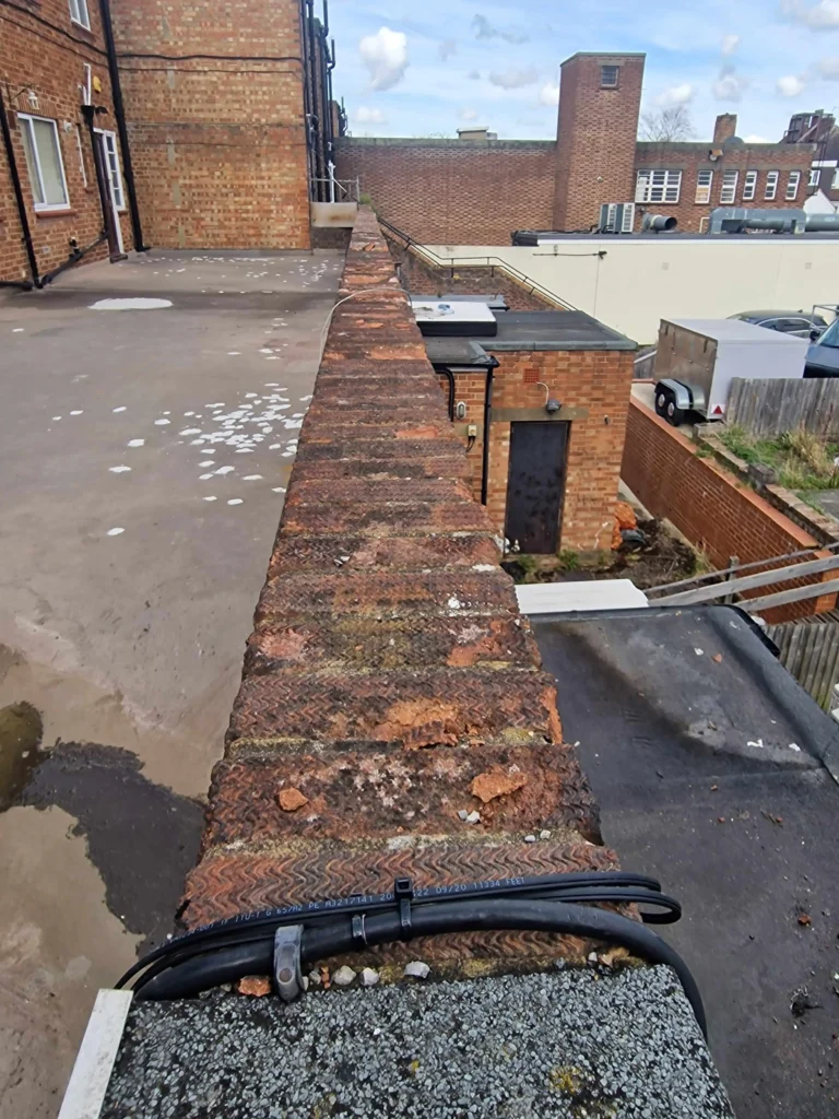 Brick wall prepared for aluminium coping with visible weathering issues
